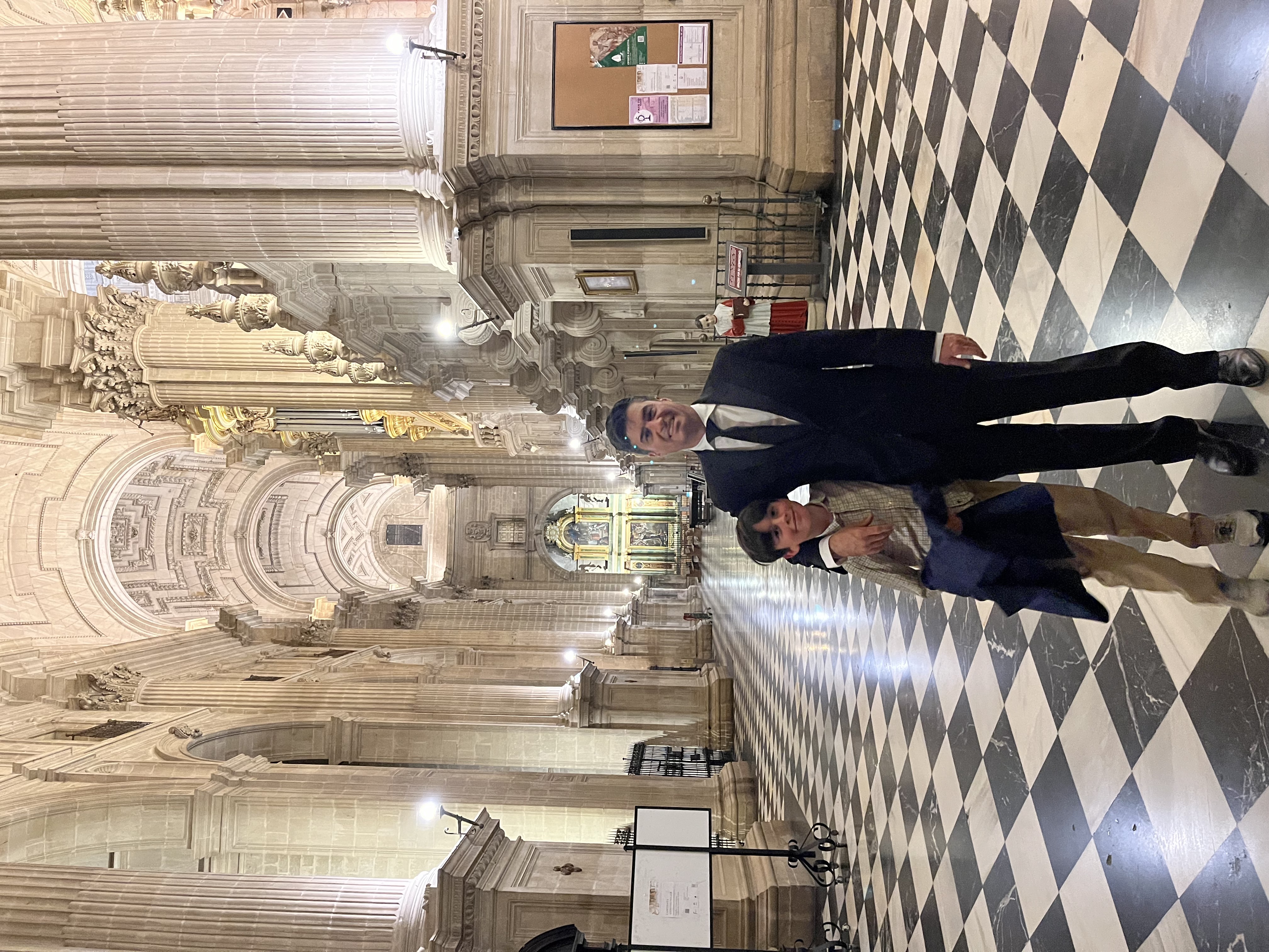 Man and boy in a historic cathedral inf front of ornate altar